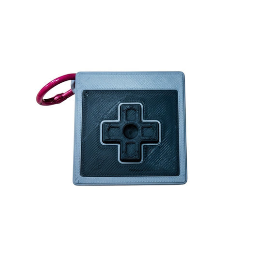 Wacky McLovin Prints NES-inspired controller keychain, grey and black 3D printed retro gaming accessory with D-pad.