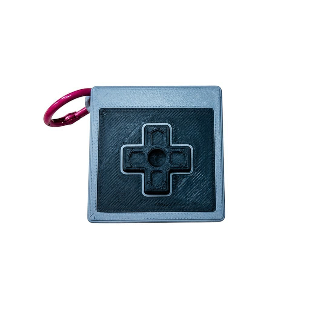 Wacky McLovin Prints NES-inspired controller keychain, grey and black 3D printed retro gaming accessory with D-pad.